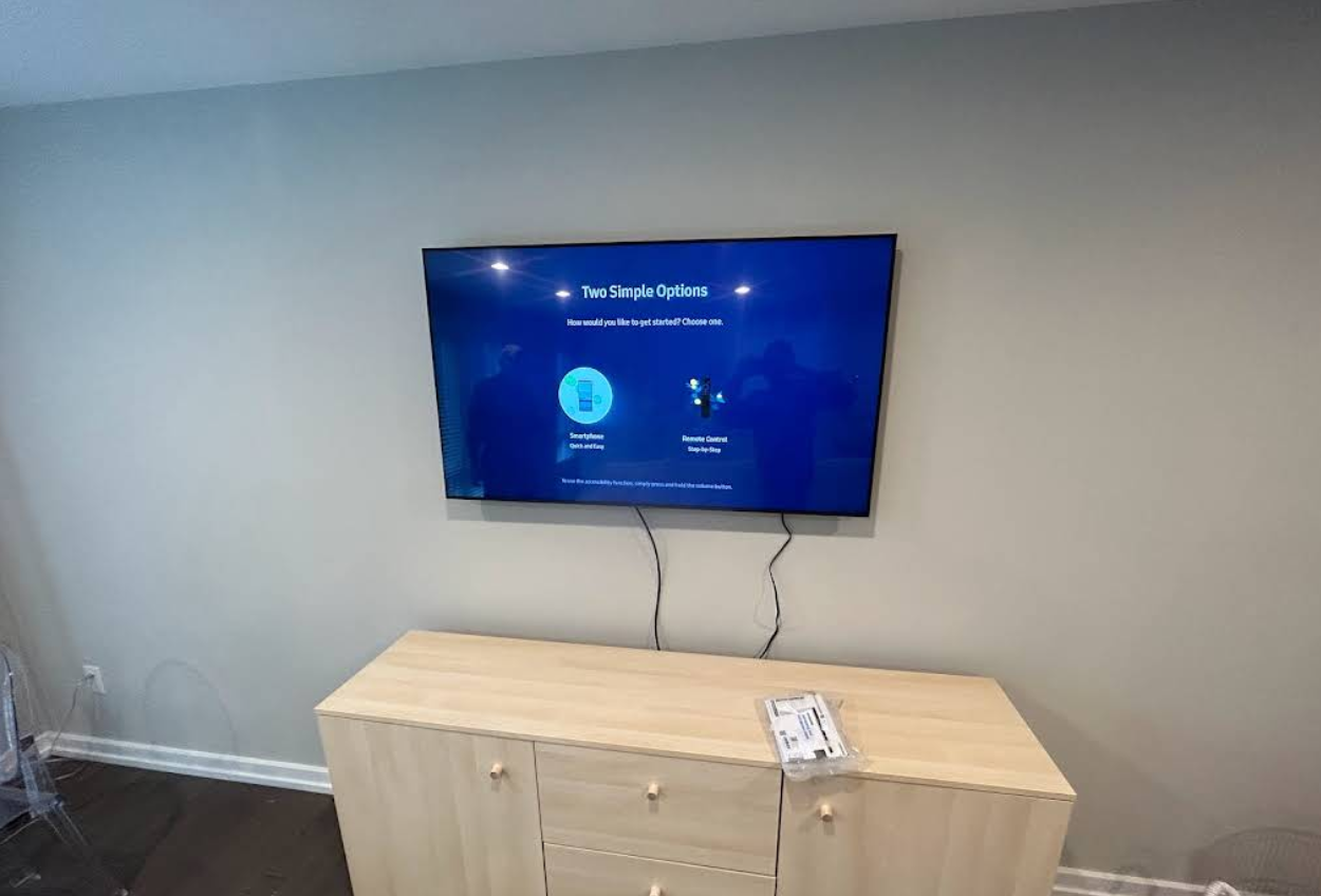 Flat screen TV mounted above a wooden console unit